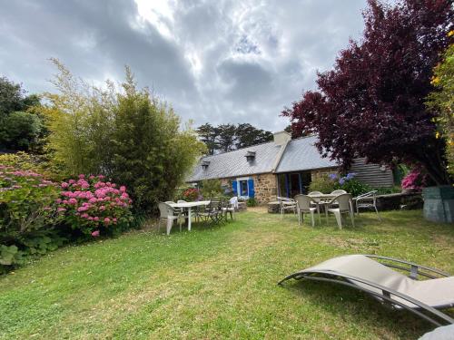 une maison avec des tables et des chaises dans la cour dans l'établissement La Maison, à Crozon