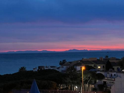 a view of a city at sunset with a street light at Calypso Holidays II in Sitio de Calahonda