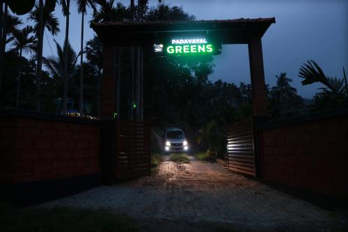 a car driving under a gate with a green sign at PADAVAYAL GREENS in Attappādi
