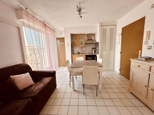 un salon avec une table et une cuisine dans l'établissement NP220-3-30 Appartement 3 pièces, Narbonne Plage, à Narbonne-Plage