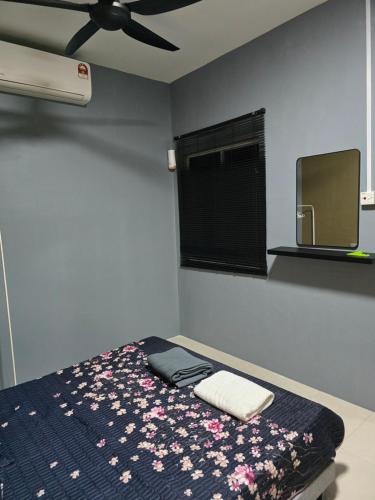 a bedroom with a bed and a ceiling fan at Humaira Homestay Teluk Intan in Teluk Intan