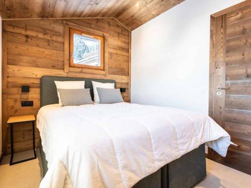 une chambre avec un lit dans une pièce aux murs en bois dans l'établissement Appartement duplex 5 pièces rénové, Crève-Coeur, 8 pers, animaux acceptés - FR-1-291-720, à Valmorel