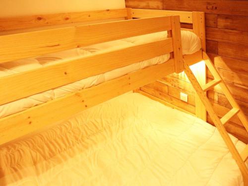 Cette chambre comprend un grand lit superposé en bois. dans l'établissement Appartement standing 6/7p avec piscine, sauna, hammam, wifi, animaux admis - Les Orres 1800 - FR-1-322-99, aux Orres