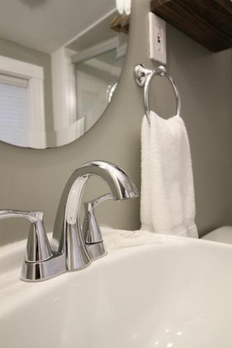 a bathroom sink with a white towel hanging from a faucet at The Aurora Inn & Cottages in Bartlett