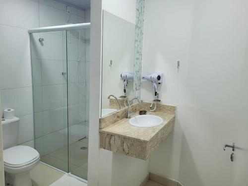 a bathroom with a sink and a toilet at Hotel Fazenda Pintado na Brasa in Guararema