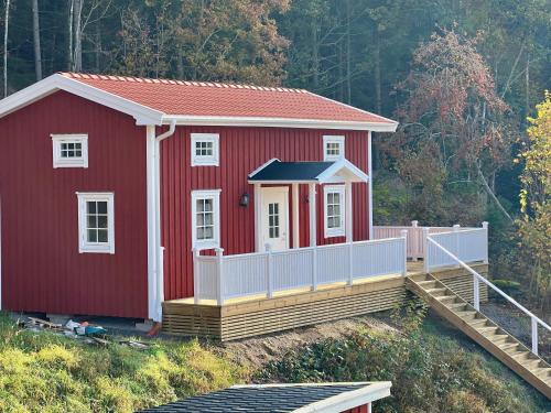 a red house with a white fence around it at Lantlig idyll in Svenshögen