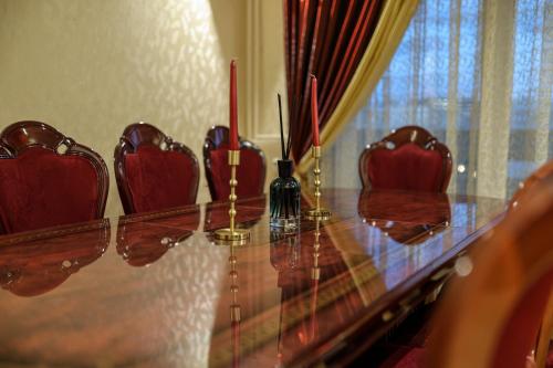 d'une table en verre avec des chaises rouges et des bougies rouges. dans l'établissement Très belle Apparemment 80 m2 Double Séjour à Strasbourg proche Zénith Gare Centrale Centre Ville CHU Hôpital, à Strasbourg