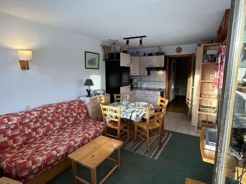 un salon avec un canapé et une table et une cuisine dans l'établissement Studio alcôve Les Saisies 4 pers, proche centre, balcon - FR-1-594-211, à Hauteluce