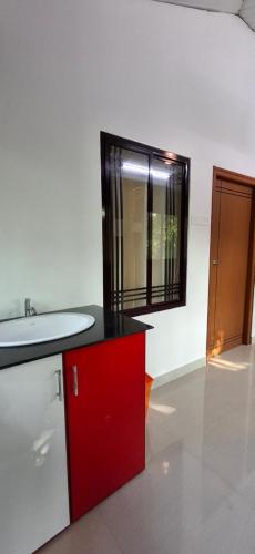 a bathroom with a sink and a red cabinet at The Pearl Munro in Munroe Island