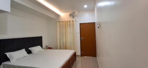 a small bedroom with a bed and a door at The Pearl Munro in Munroe Island