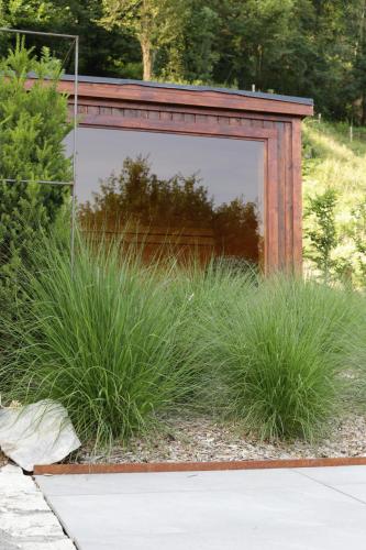 a mirror in a garden with tall grass at Cascina Belvedì in Clanezzo