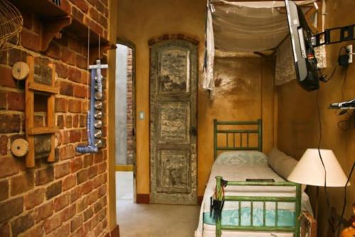a bedroom with a bed and a brick wall at Modernistas Arte in Rio de Janeiro
