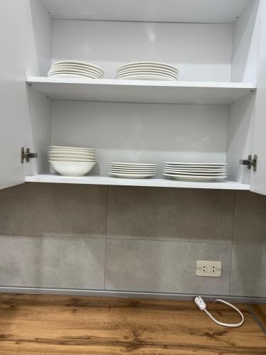 a kitchen with plates and bowls on shelves at Velvet Vouge Hostel in Yerevan