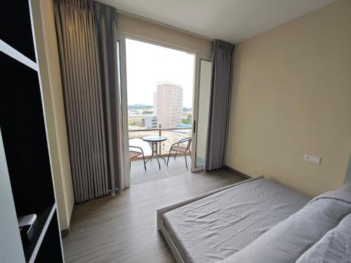 a bedroom with a bed and a balcony with a table at Nagoya Thamrin Cozy Apartment 11TH City View in Nagoya