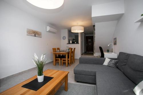 a living room with a couch and a table at Stunning & Cosy, Direct Pool Access, 2BR, with Private Patio! Serenity Townhouse in Paphos