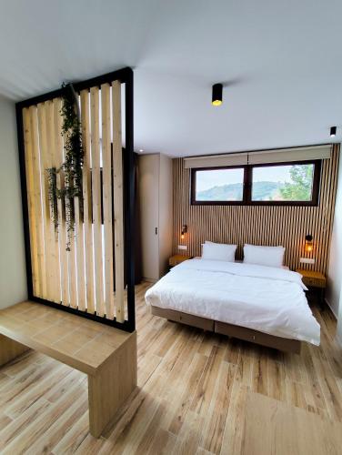 a bedroom with a bed and a large window at Meteora Gold and Glass Suites in Kalabaka