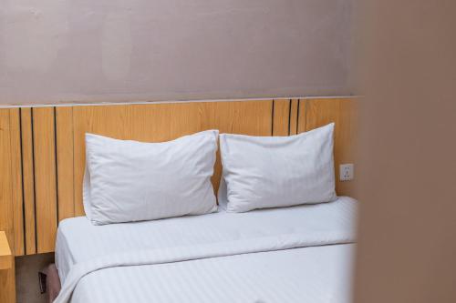 a bed with two white pillows and a wooden headboard at A'rabia Style Wahid Hasyim in Medan