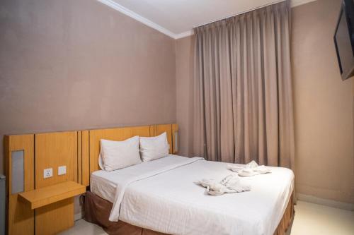 a bedroom with a bed with towels on it at A'rabia Style Wahid Hasyim in Medan
