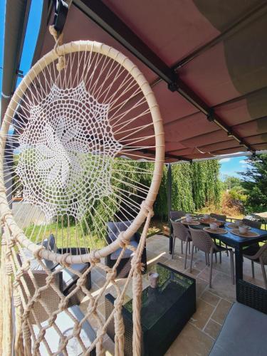 a large woven rattan swing on a patio at L'Échappée Belle près de Toulouse in Castelnau-dʼEstrétefonds