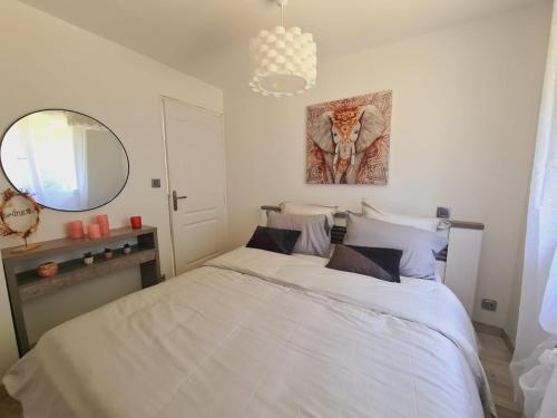 a bedroom with a white bed and a mirror at L'Échappée Belle près de Toulouse in Castelnau-dʼEstrétefonds