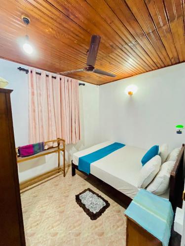 a bedroom with a bed and a wooden ceiling at Ranga's House in Weligama