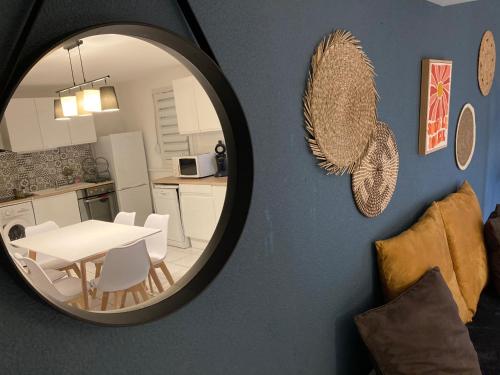 un miroir mural avec une table et une cuisine dans l'établissement La Maison de la Gardiole, à Frontignan
