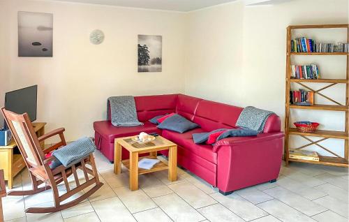 un canapé rouge dans un salon avec une table dans l'établissement Ferienwohnung Graal-Müritz, à Graal-Müritz
