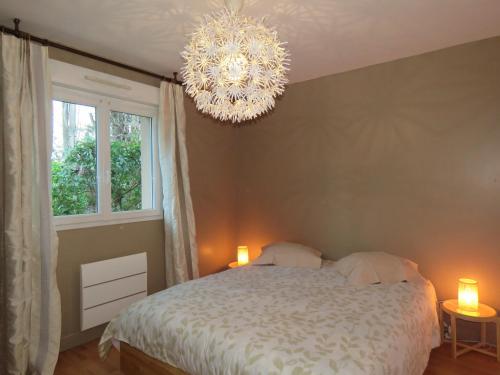 une chambre avec un lit et un lustre dans l'établissement Maison calme proche mer, à Ver-sur-Mer