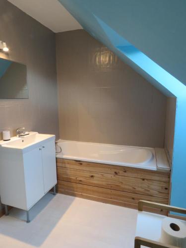 une salle de bain avec une baignoire et un lavabo dans l'établissement Maison calme proche mer, à Ver-sur-Mer