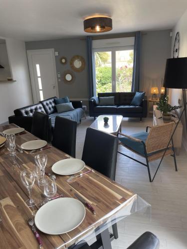 un salon avec une table et un canapé dans l'établissement Maison calme proche mer, à Ver-sur-Mer