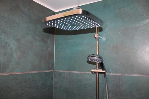 a shower with a shower head in a bathroom at STAY Billund in Vandel