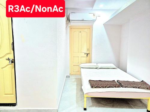 a white room with a bed and a yellow door at Shriguru Guest House Akkalkot in Akalkot