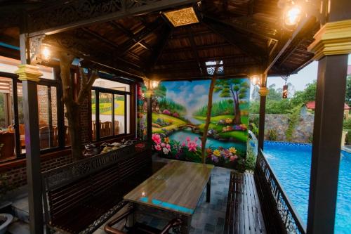 a mural on the side of a house with a bench at Tam Coc Chu Chu Villa in Ninh Binh