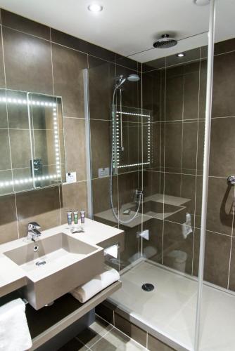 a bathroom with a sink and a shower at Novotel Nottingham Derby in Long Eaton