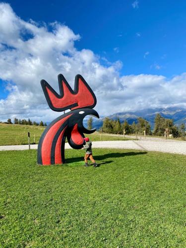 a boy walking past a large statue in the grass at Appartements Wiesenheim in Rasun di Sopra