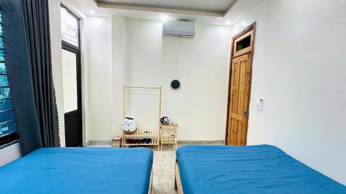a bedroom with two blue beds and a mirror at ToTo-Chan Hotel in Dồng Văn