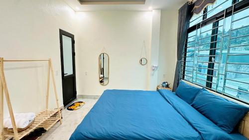a bedroom with a blue bed and a window at ToTo-Chan Hotel in Dồng Văn