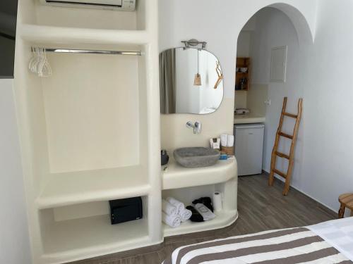 a bedroom with a bed and a sink and a mirror at Theofanis on the beach in Agia Anna Naxos