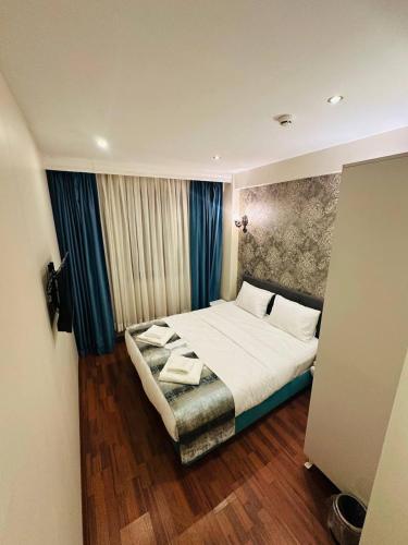 a bedroom with a large bed and blue curtains at By Historial Hotel Due in Istanbul