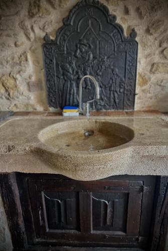 La salle de bains est pourvue d'un lavabo et d'un mur en pierre. dans l'établissement Le Domaine de Pépé, à Saint-Julien-de-Briola