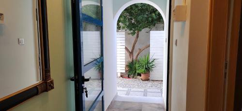 an open door to a yard with a tree at villa vagelis in Mourteri