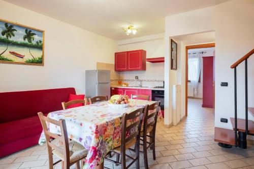 a kitchen and dining room with a table and chairs at Follonica Apartments - Pool & Relax in Follonica