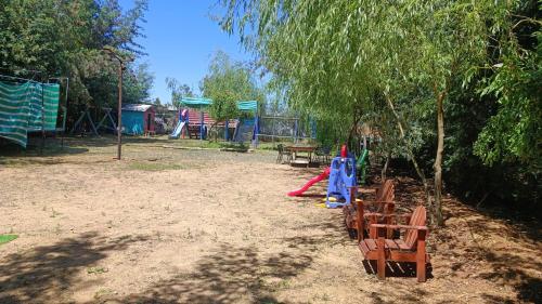 a park with a playground with a swing set at Las palmeras de Colbún in Colbún