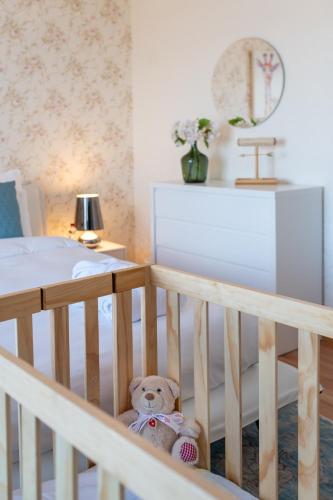 a teddy bear sitting in a crib in a bedroom at Montreux Lake View Apartments and Spa - Swiss Hotel Apartments in Montreux