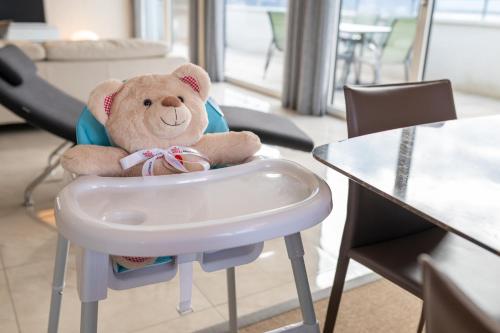 a teddy bear sitting in a high chair at Montreux Lake View Apartments and Spa - Swiss Hotel Apartments in Montreux