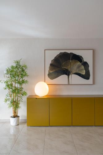 a yellow cabinet in a room with a plant at Montreux Lake View Apartments and Spa - Swiss Hotel Apartments in Montreux