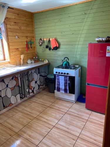 a kitchen with a stove and a refrigerator at Las palmeras de Colbún in Colbún