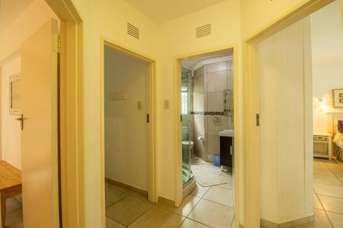 a hallway with yellow walls and a bathroom with a mirror at Marine Glen 12 in Ramsgate