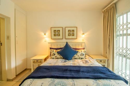 a bedroom with a large bed with blue pillows at Marine Glen 12 in Ramsgate
