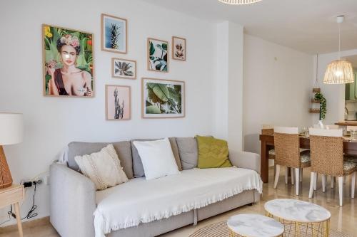a white living room with a couch and a table at Ultimate Rentals - Gezellig Stijlvol Appartement Dichtbij Het Strand - Communal Pool in Estepona